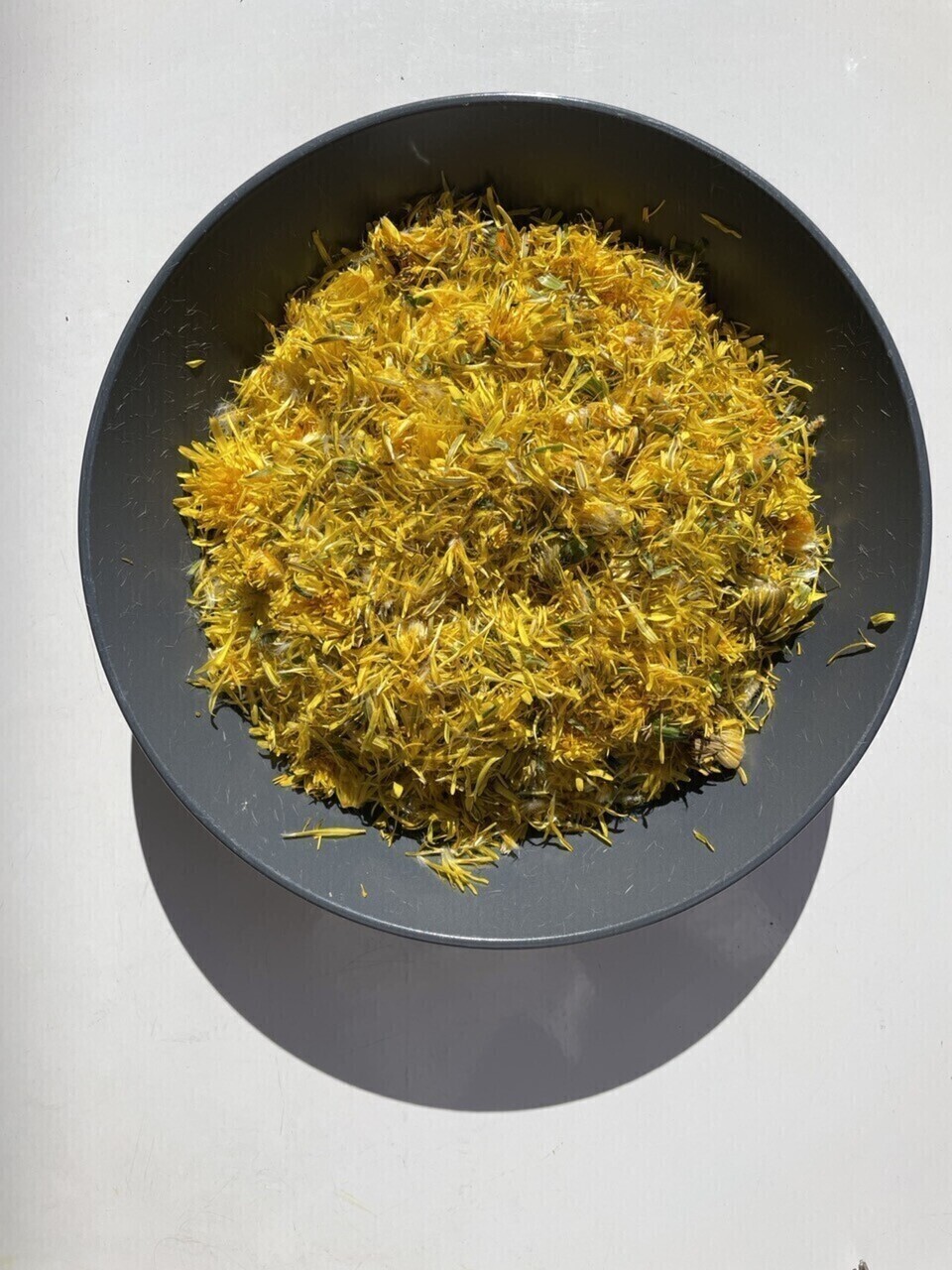 A plate full with dandelion petals, all yellow and fluffed up.